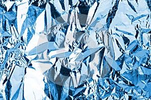 Crumpled light blue foil shining texture background, bright shiny cold icy design, metallic glitter surface