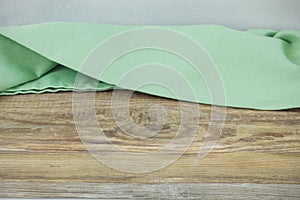 Crumpled napkin on wooden table over grey wall background