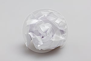 Crumpled paper ball lying on gray background