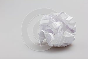 Crumpled paper ball lying on gray background