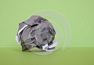 crumpled paper ball over green