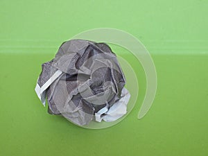 crumpled paper ball over green