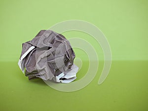 crumpled paper ball over green