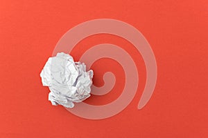 Crumpled paper ball on red background for business concept