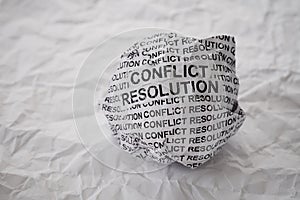 Crumpled paper ball with words Conflict Resolution on crumpled white paper background
