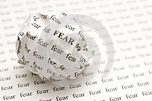Crumpled paper ball with words fear