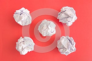 Crumpled paper balls on red background