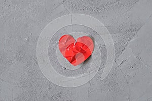 Crumpled paper heart in gift box on the concrete floor.  Broken relationships in bad Valentine`s day. concept.