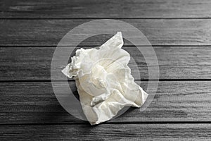 Crumpled paper napkin on wooden background.