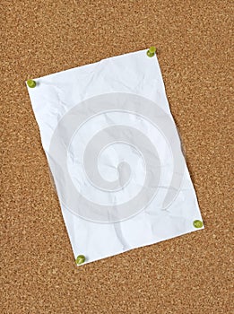 Crumpled paper pinned to corkboard