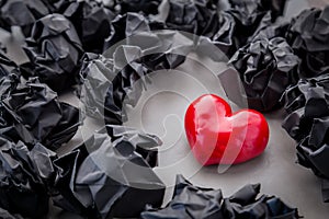 Crumpled paper with red heart on grey background