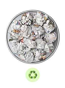 Crumpled papers in garbage bin with recycling sign over white background