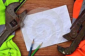 A crumpled sheet of paper with two pencils surrounded by green a