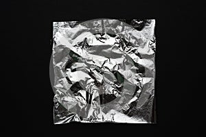 crumpled sheet of silver on a black background. abstract relief material