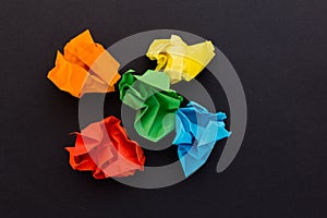 Crumpled sheets of colored paper on a black background