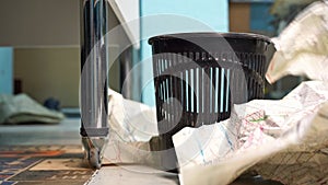 Crumpled sheets of paper fall into trash basket in workshop closeup