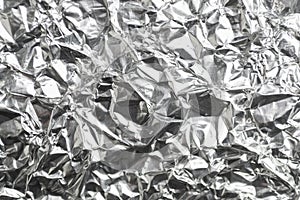 Crumpled silver aluminum foil surface texture background closeup