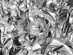 Crumpled silver foil texture. Shiny festive background. Metallized paper.