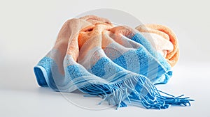 Crumpled soft throw blanket in orange and blue with tassels, on a white background