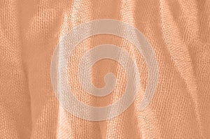 Crumpled textiles close-up. Color peach fuzz