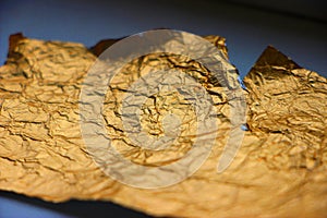 Crumpled torn golden bronze foil texture background