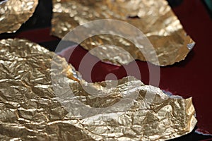 Crumpled and torn golden bronze shiny foil texture background