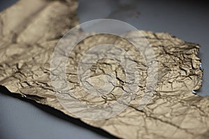 Crumpled and torn golden bronze shiny foil texture background