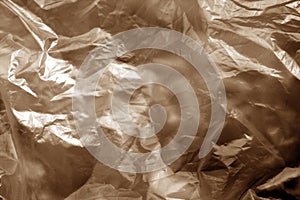 Crumpled transparent plastic  surface in brown tone