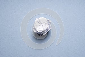 Crumpled-up ball of paper on blue background