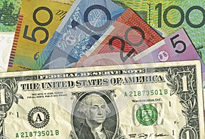 A crumpled US dollar bill over Australian money