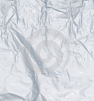 Crumpled wet plastic texture background. Crumpled plastic with water drop