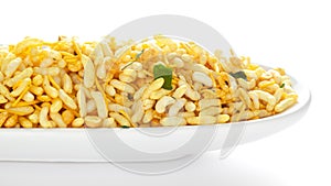 Crunchy Murmura in a white ceramic oval bowl made with Puffed Rice and Curry leaves.