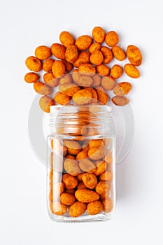 Crunchy Peanut spilled and in a glass jar, made with besan coated peanuts.