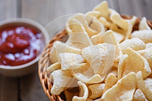 Crunchy prawn crackers or shrimp crisp rice and ketchup for traditional snack - prawn crackers chips on basket and wooden table