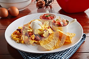 crunchy Tex Mix snacks with dip sauce served in a dish isolated on wooden background side view