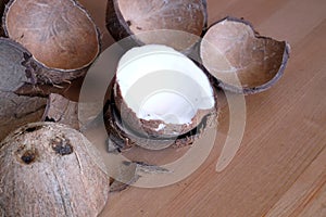 Crushed coconut shell and coconau fruit on wooden background