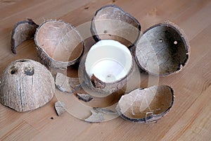 Crushed coconut shell and coconau fruit on wooden background