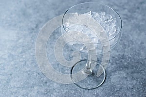 Crushed Ice in Cocktail Glass on Blue Surface.