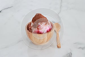 Crushed ice Or shaved ice with sweet red water and sweetened condensed milk, Topped with chocolate powder, looks like a volcano.