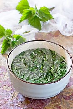 The crushed leaves brewed raw nettles on the kitchen table a rustic background