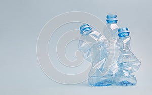 Crushed pet plastic bottles on blue background, recycling and environment concept