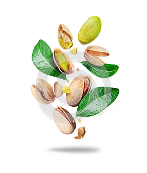 Crushed pistachios with leaves in the air close up isolated on a white background