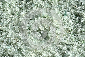 Crushed small pieces of glass are gathered for recycling in a machine in a recycling facility.