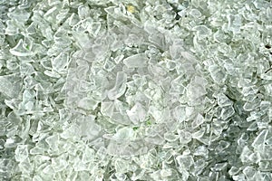 Crushed small pieces of glass are gathered for recycling in a machine in a recycling facility.