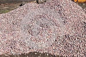 Crushed stone mound. Red crushed stones. Versatile building material for horticulture, landscape gardening or road construction.