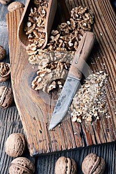 Crushed walnut nuts kernels and knife