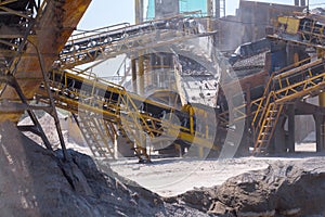 Crushing machinery, cone type stone crusher, conveying crushed granite gravel stone in a quarry open pit mining. Processing plant photo