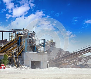 Crushing machinery, cone type stone crusher, conveying crushed granite gravel stone in a quarry open pit mining. Processing plant