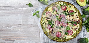 Crust Broccoli base low carbs keto pizza with salami, avocado on vintage newspapper. Top view photo