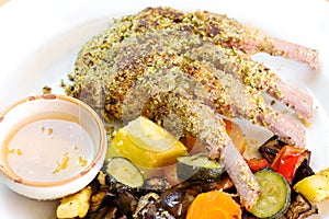 Crusted lamb ribs with pistachio grains  and steamed vegetables